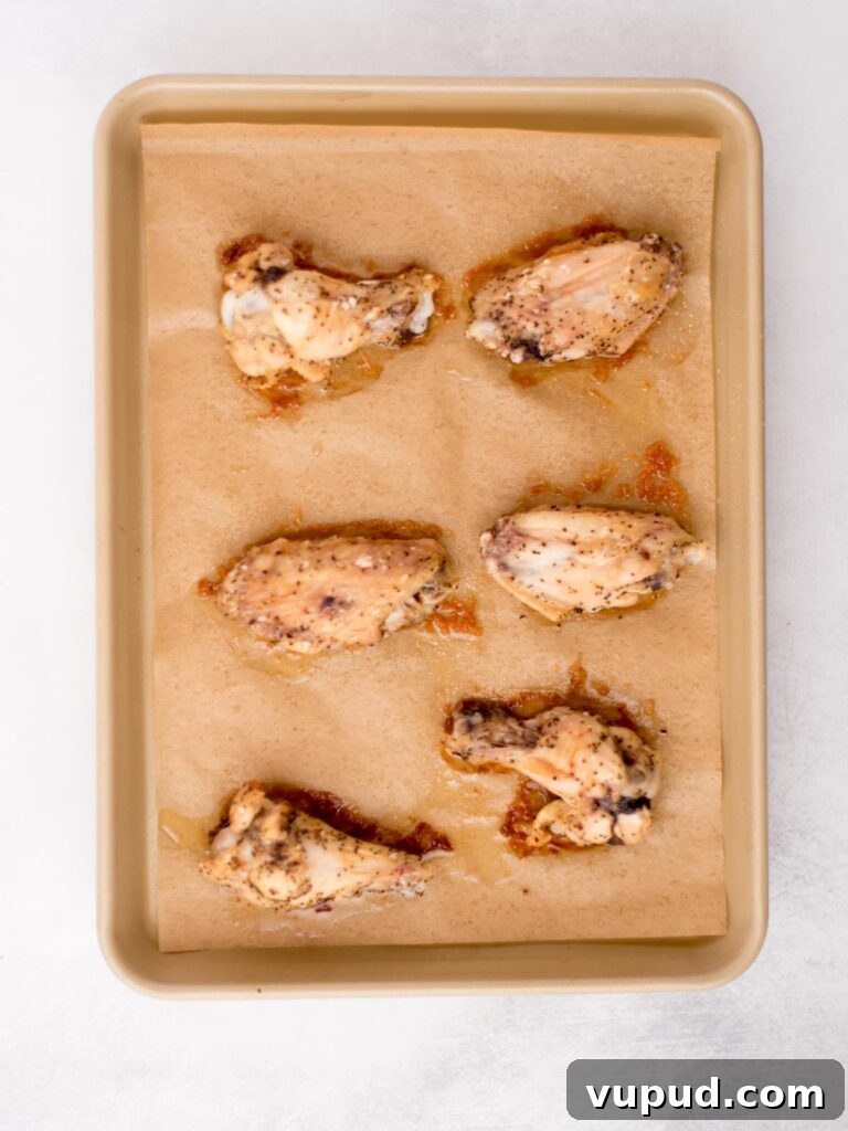 Tequila-Lime Chicken Wings: Zesty Grilled Wing Recipe 6 Seasoned chicken wings on a baking sheet.