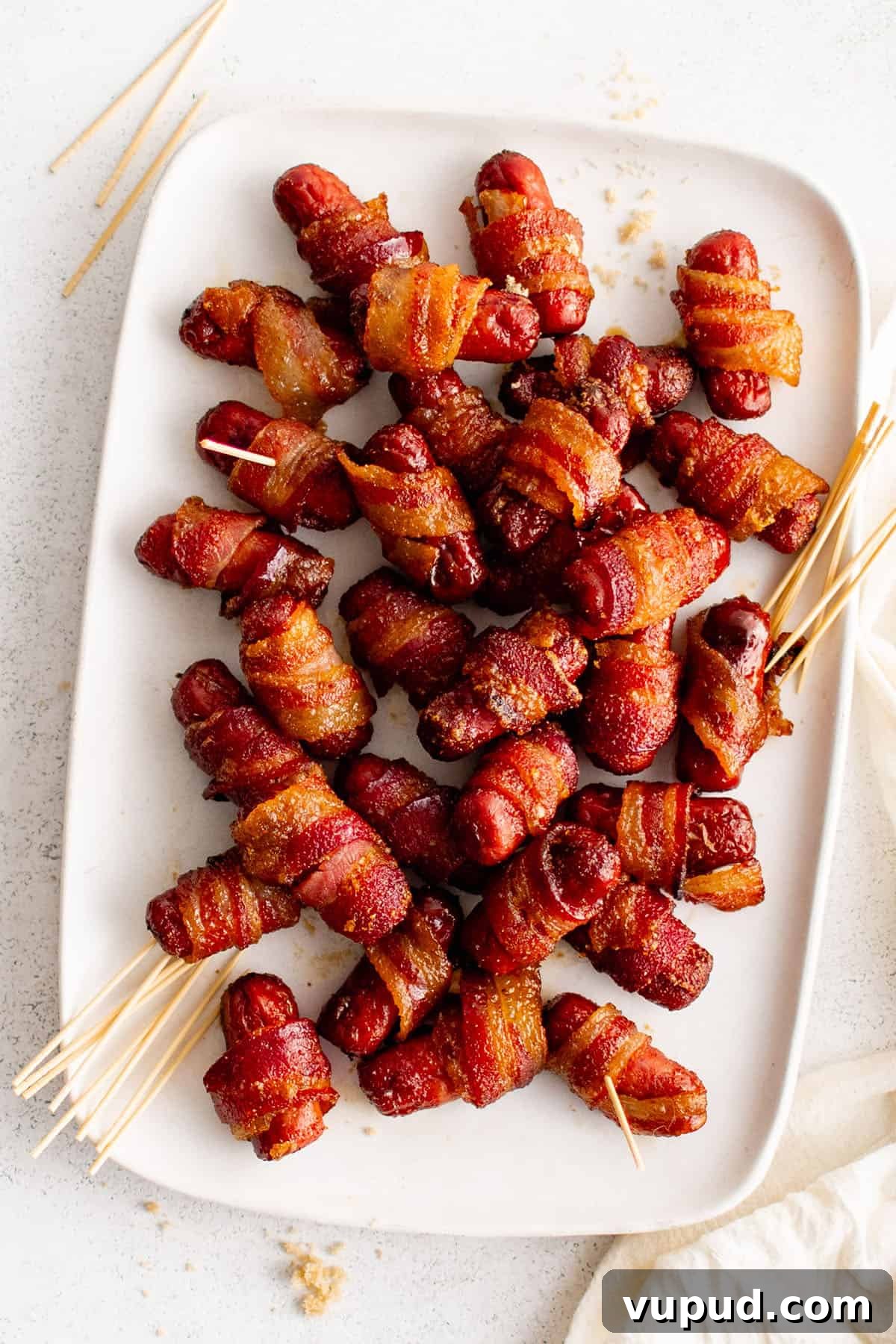 Smoky Bacon-Wrapped Cocktail Sausages Recipe 2 lil smokies wrapped in bacon on a plate