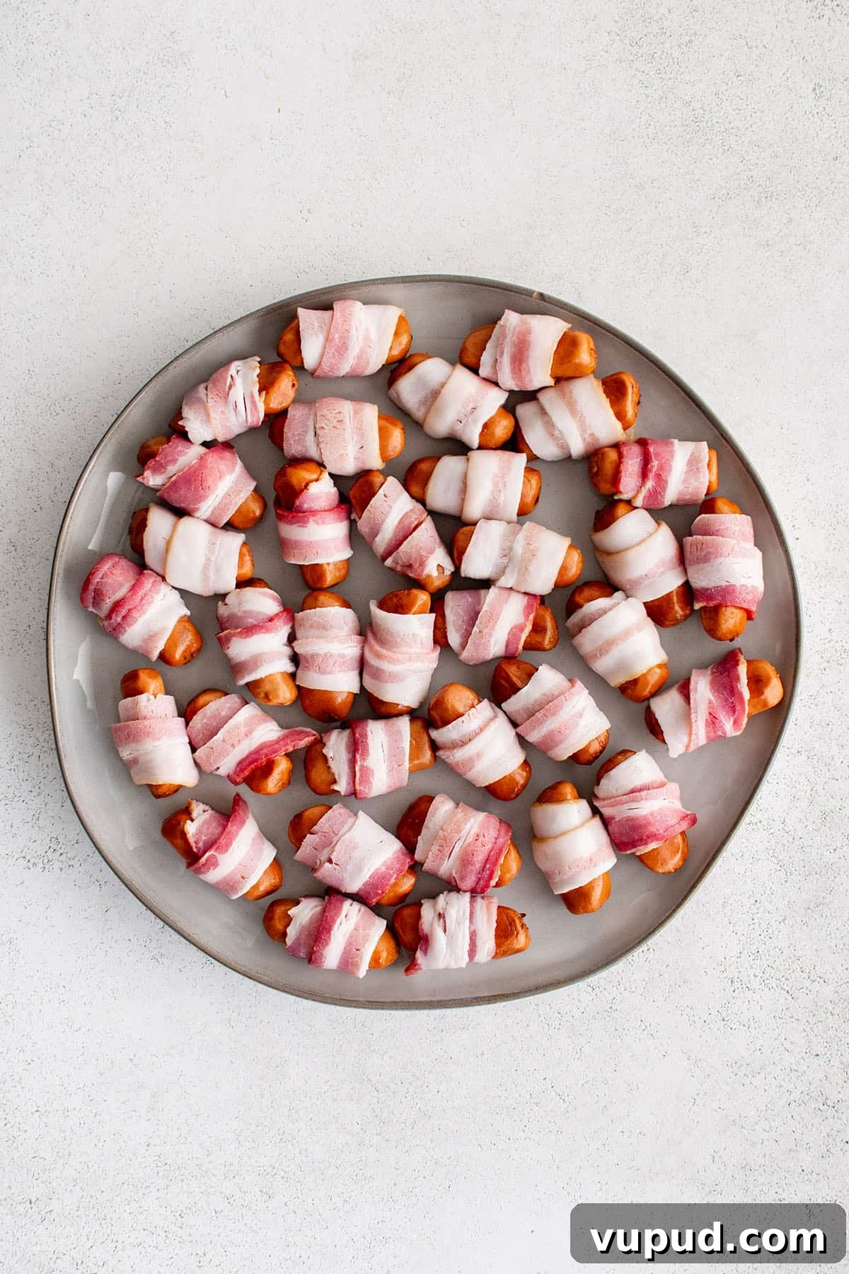 Smoky Bacon-Wrapped Cocktail Sausages Recipe 3 lil smokies with bacon wrapping on a platter