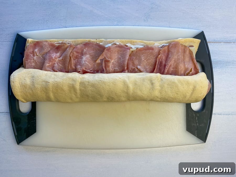 Quick Ham and Cheese Roll-Ups: 4-Ingredient Party Snack 10 Starting to roll the ham and cheese up in refrigerated dough