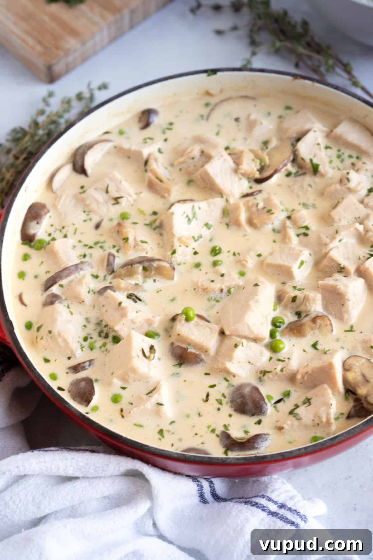 Leftover turkey fricassee in a red pan.
