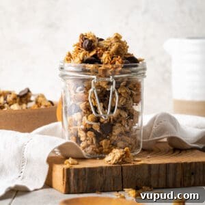Homemade Chocolate Banana Granola Recipe for Crunchy Breakfast 14 A jar of chocolate banana granola on a wooden cutting board.