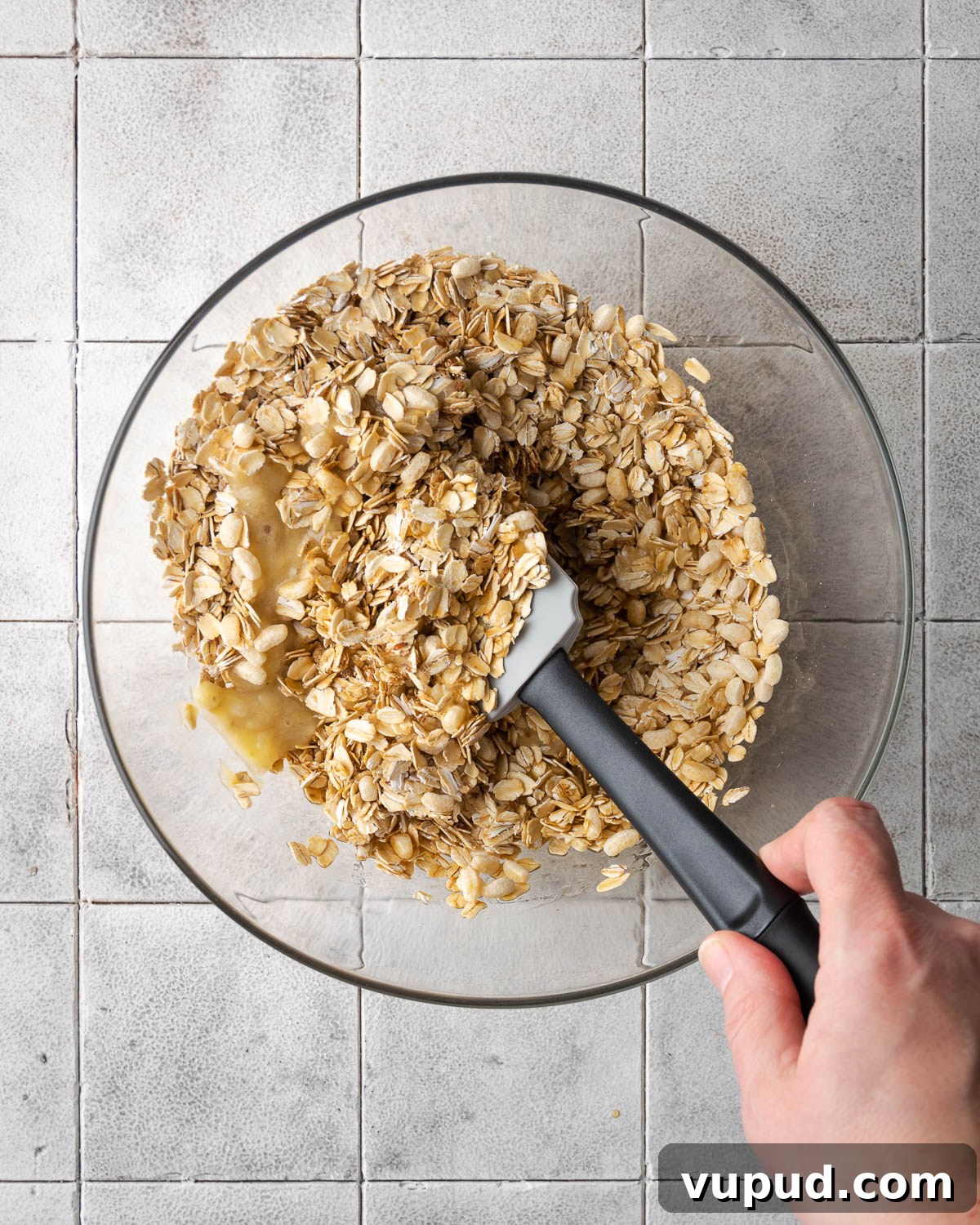 Homemade Chocolate Banana Granola Recipe for Crunchy Breakfast 6 Granola being mixed together with a rubber spatula.