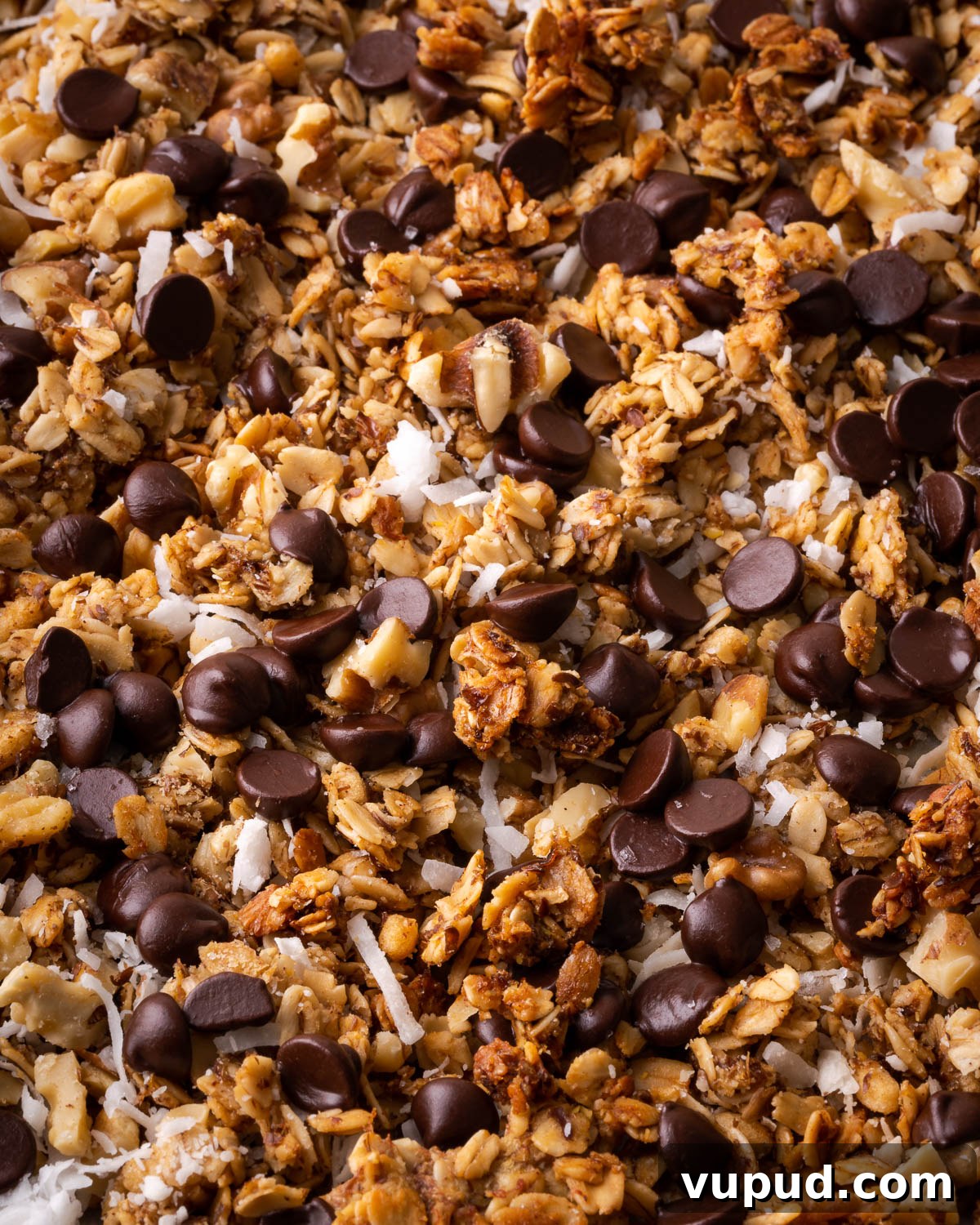Homemade Chocolate Banana Granola Recipe for Crunchy Breakfast 8 Golden brown granola sprinkled with chocolate chips, shredded coconut and chopped walnuts.