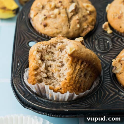 A closeup of a banana nut muffin with a bite taken out.