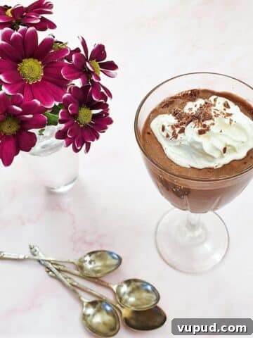 A glass of peppermint chocolate mousse, topped with whipped cream.