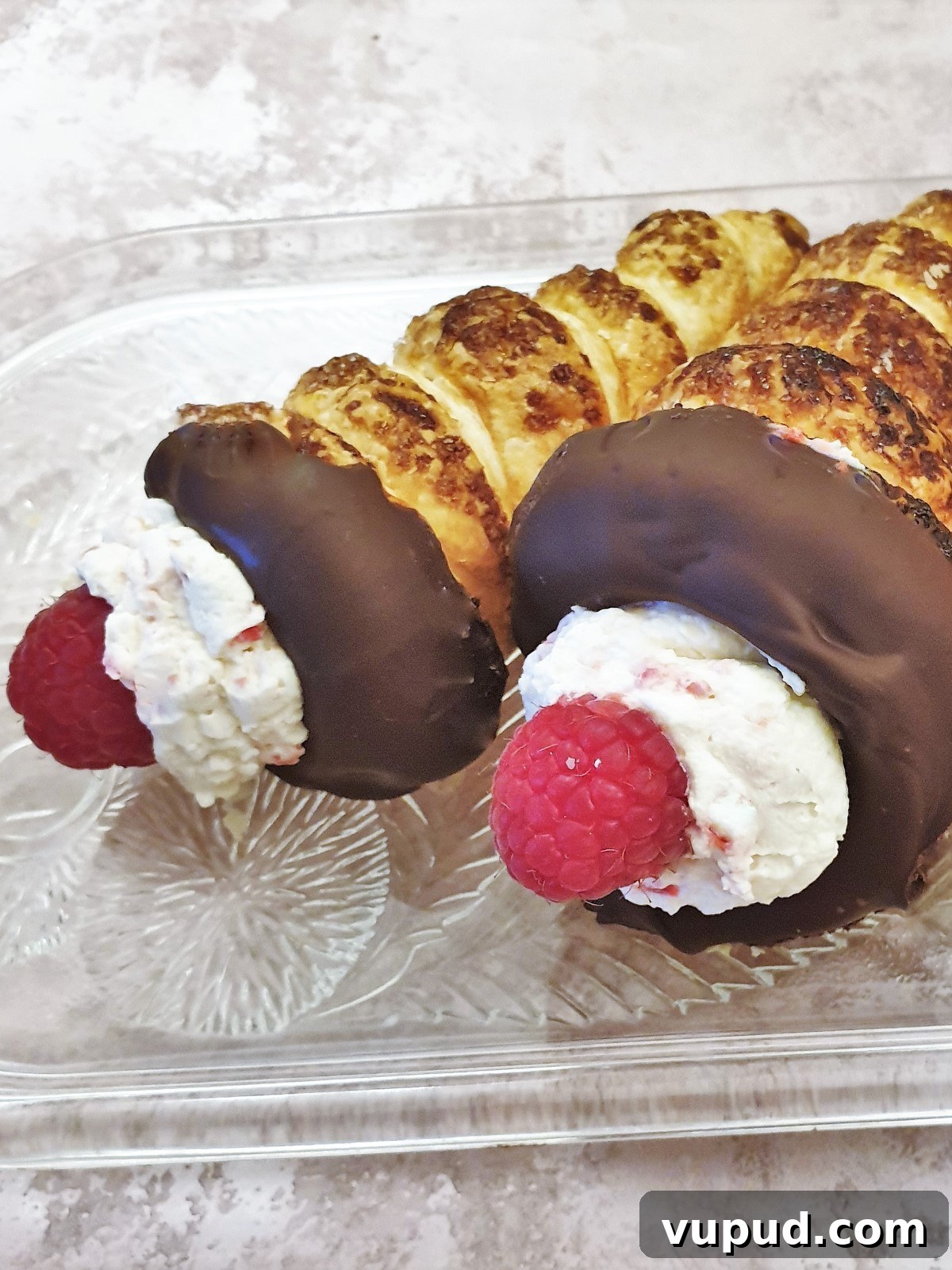 Raspberry Cream Horns with Rich Dark Chocolate Filling 3 Closeup of 2 cream horns on a plate.
