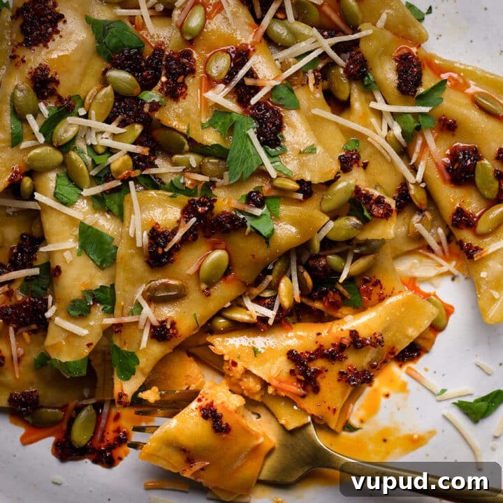 A plate filled with butternut squash pansotti in brown butter sage sauce.