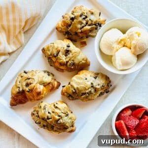 How to Make a Crookie: Viral Croissant Cookie Recipe from TikTok 4 crookie croissant stuffed with cookie on a plate with a bowl of ice cream.