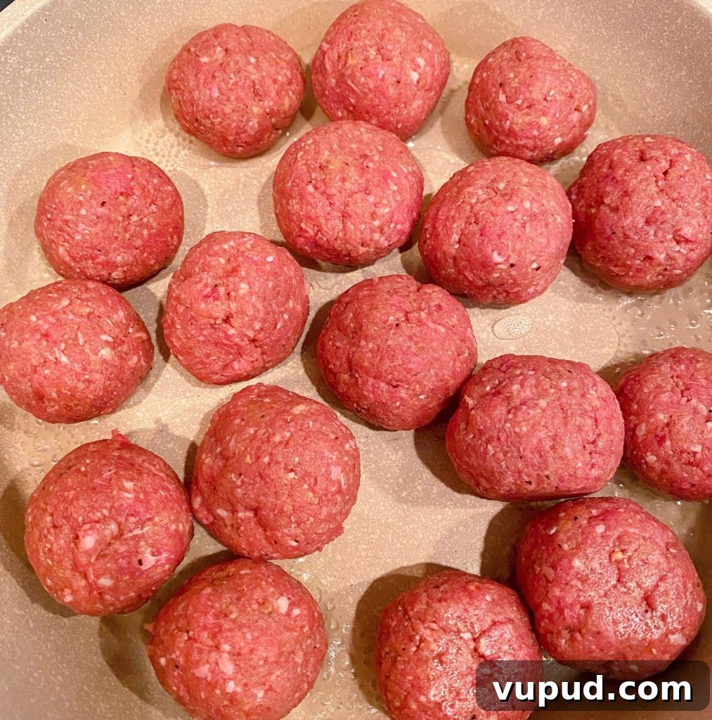 Cheesy Meatball and Hash Brown Casserole Recipe 5 Meatballs rolled and sitting in skillet.