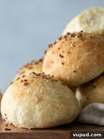 Baked focaccia rolls on top of wooden board.