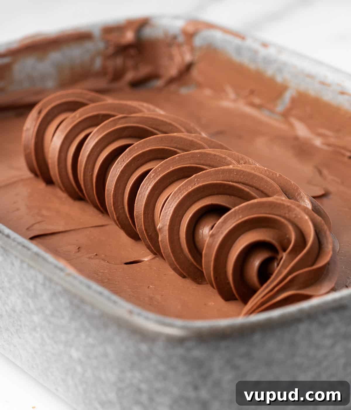 Namelaka: Silky Chocolate Cream Ganache Recipe and Guide 6 Row of piped namelaka over a layer of cream in a small grey dish.