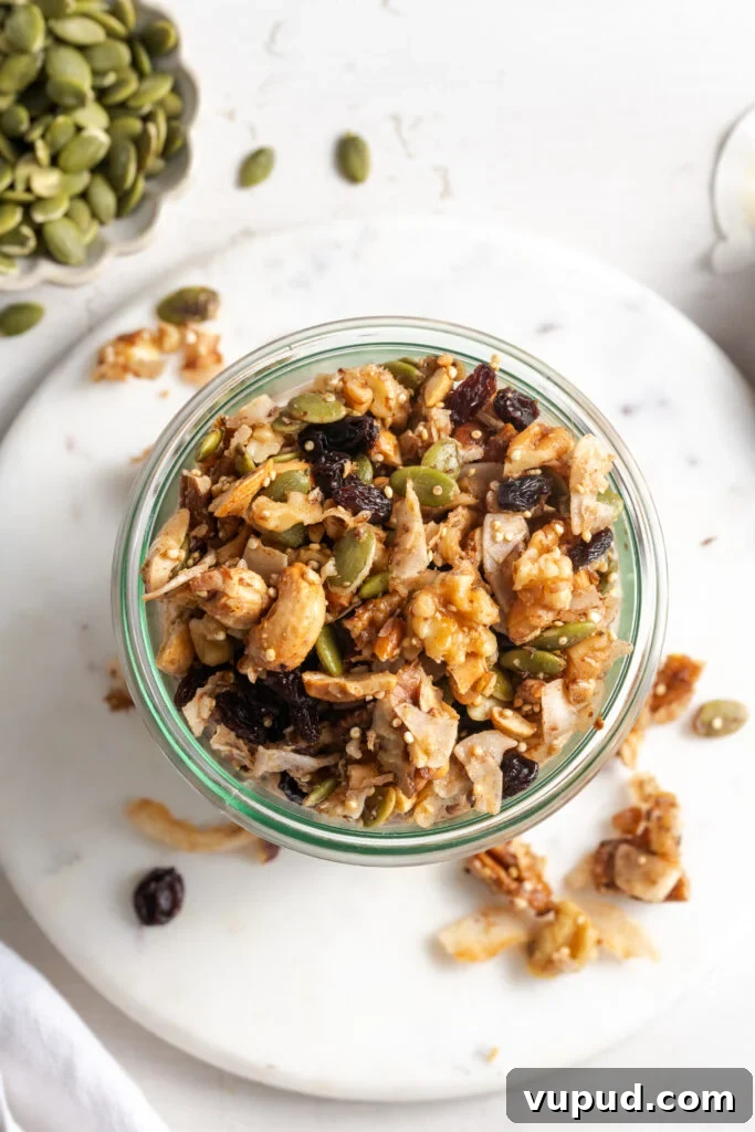 Grain-Free Homemade Granola Recipe for Crunchy, Low-Carb Mornings 15 flat lay shot of grain-free granola in a jar on a white marble round serving tray on a white table with some of the granola scattered around.