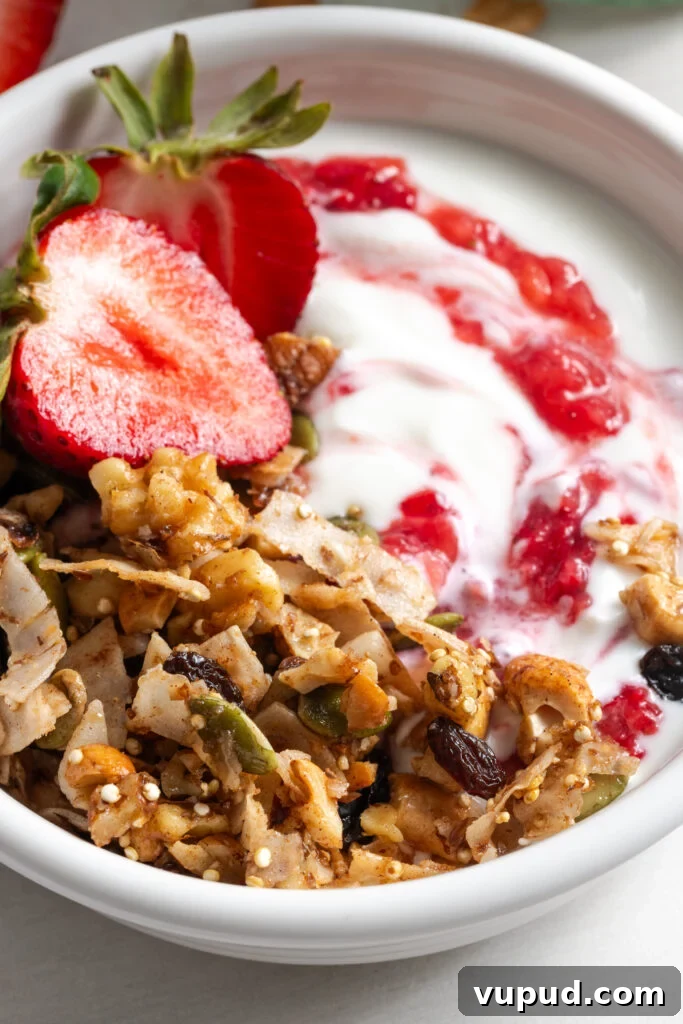 Grain-Free Homemade Granola Recipe for Crunchy, Low-Carb Mornings 16 closeup shot of a small bowl of yogurt topped with grain-free oat free granola and strawberry jam.