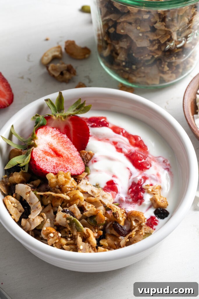Grain-Free Homemade Granola Recipe for Crunchy, Low-Carb Mornings 3 closeup shot of a yogurt parfait made with oat free grain free granola and fresh strawberries.