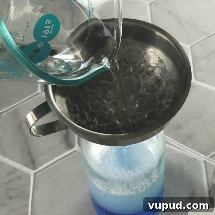 DIY Shower Cleaner Recipe for Sparkling, Streak-Free Tiles 5 Pouring vinegar into bottle