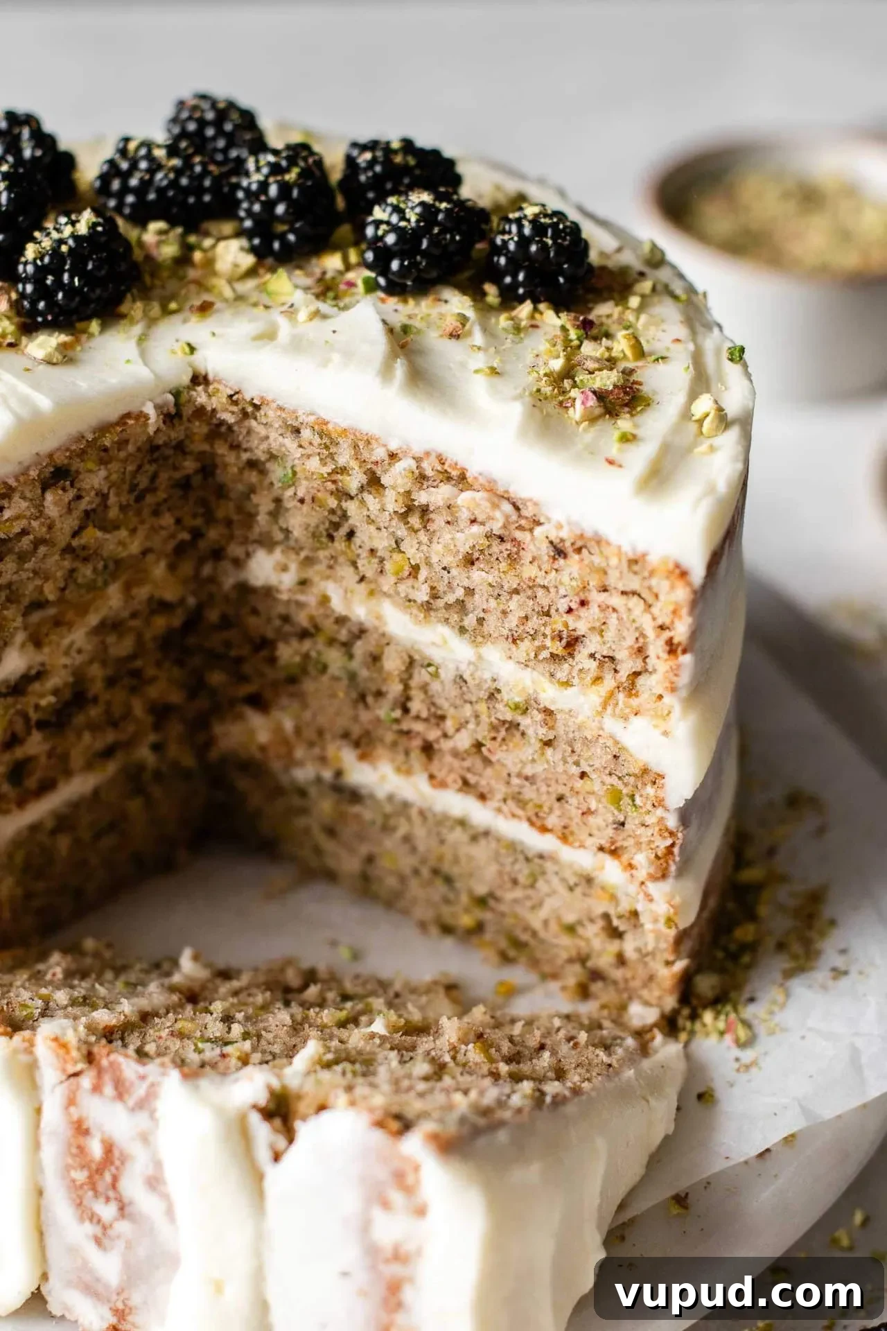 Silky Pistachio Layer Cake with Toasted Nut Crumble 12 sliced pistachio cake on cake plate
