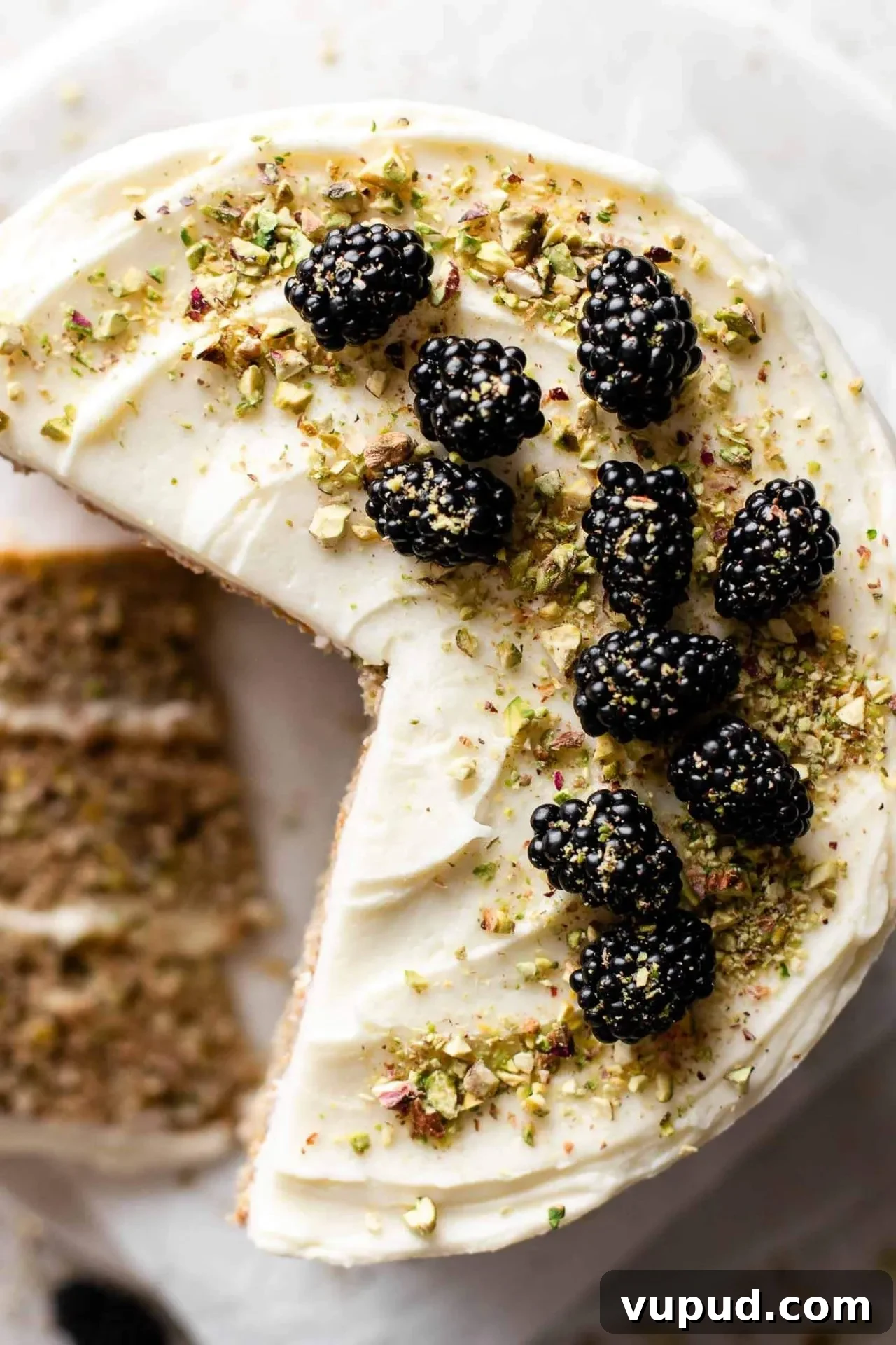 Silky Pistachio Layer Cake with Toasted Nut Crumble 3 sliced pistachio cake on cake plate