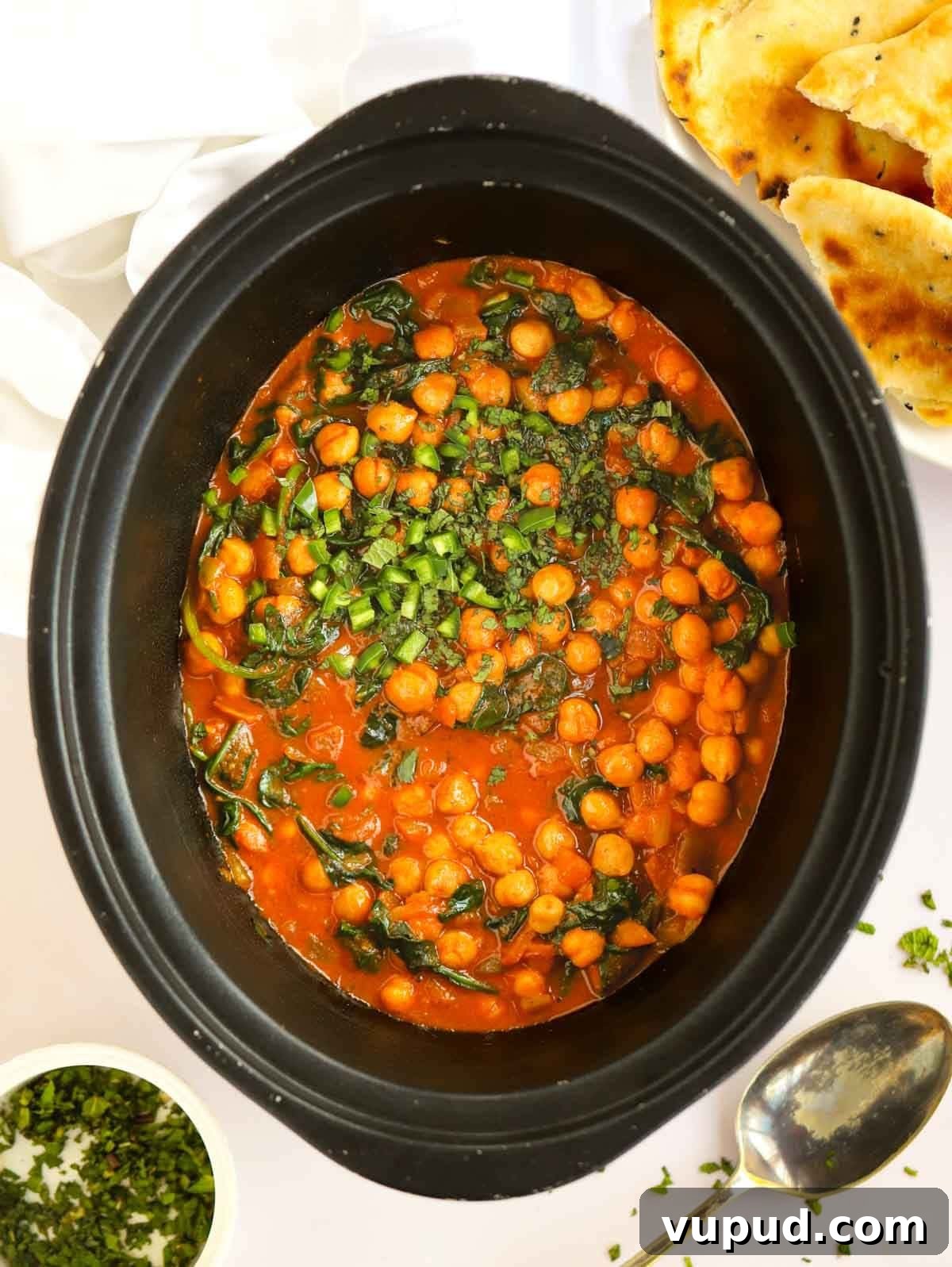 Slow-Cooked Chickpea and Spinach Curry (Chana Saag) 2 Slow cooker pan filled with chickpeas and spinach.