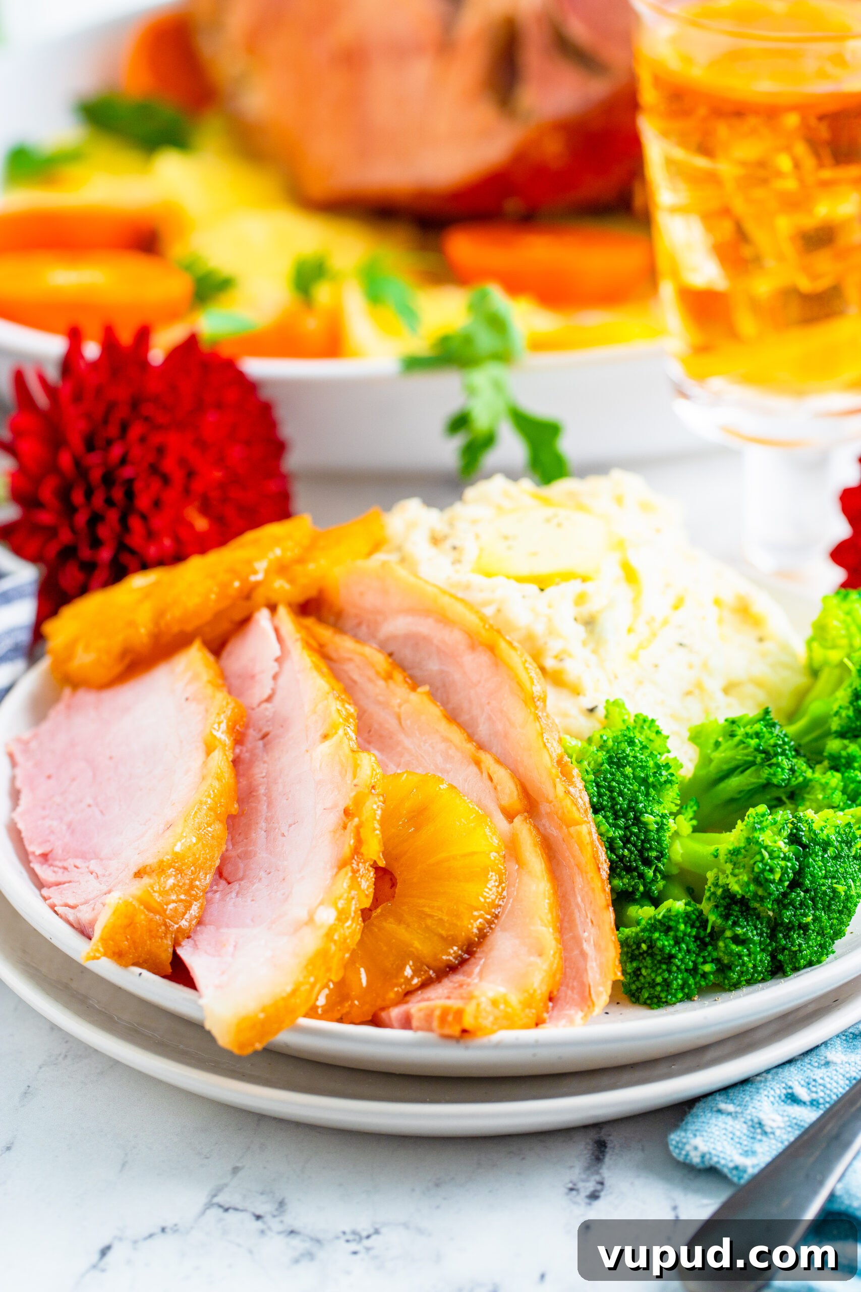 Glazed Pineapple Baked Ham Recipe for Holiday Dinner 14 Slices of baked ham plated with broccoli and mashed potatoes.