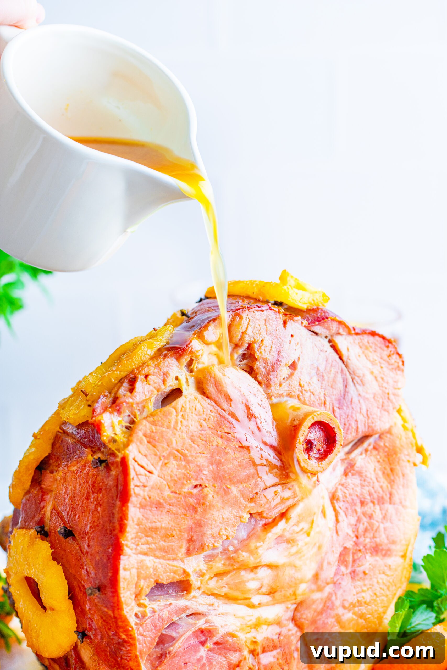 Glazed Pineapple Baked Ham Recipe for Holiday Dinner 3 Pouring gravy over top of the finished baked ham.