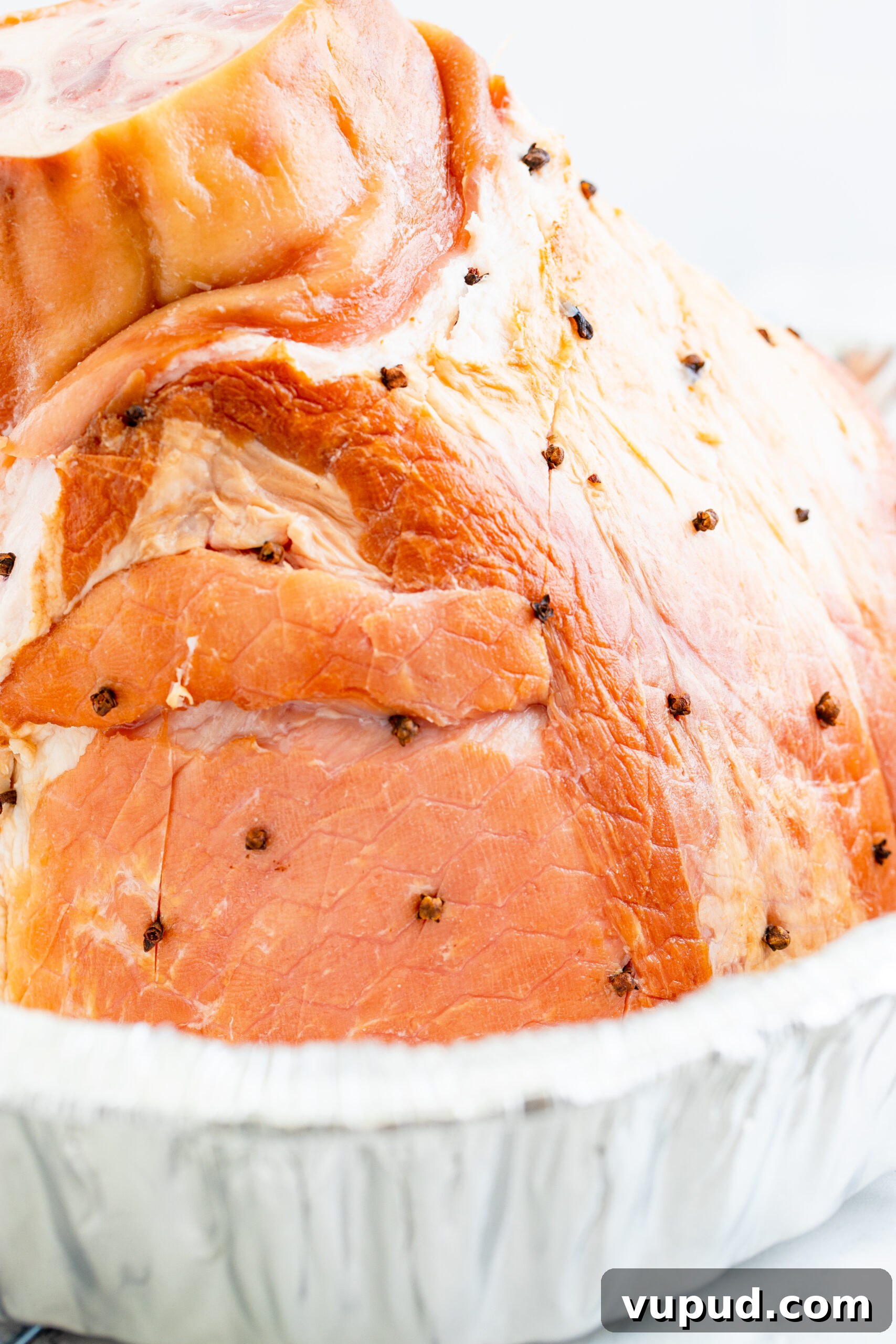 Glazed Pineapple Baked Ham Recipe for Holiday Dinner 5 placing whole cloves into the side of the ham.