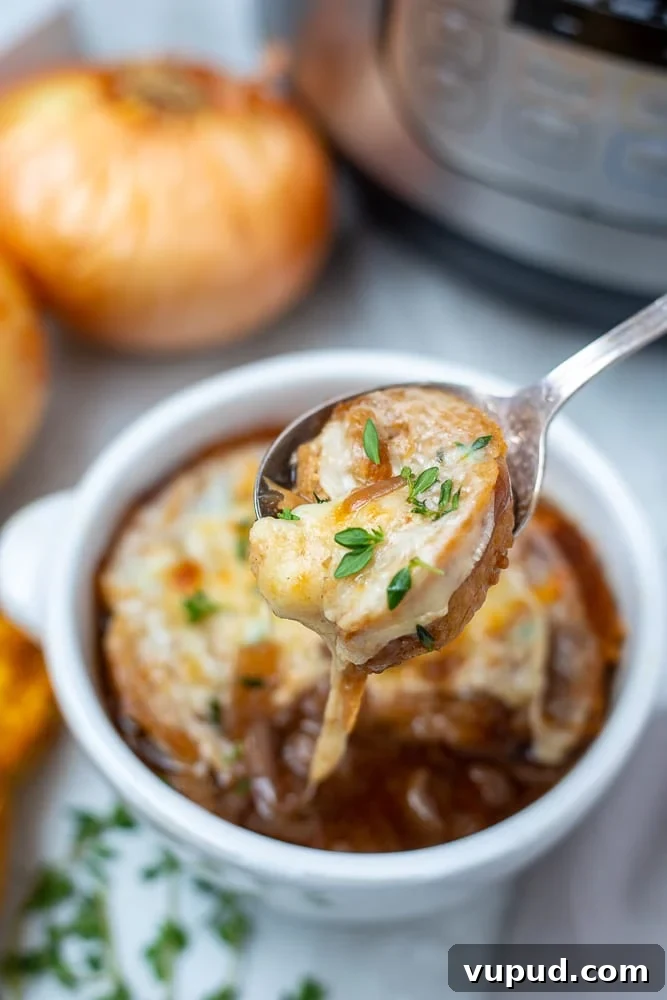 Instant Pot French Onion Soup Bowl of Instant Pot French Onion Soup with spoon pulling out cheese pull.