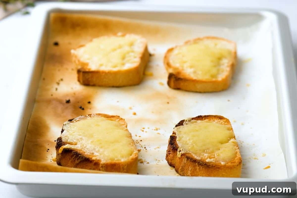 Pressure Cooker Instant Pot French Onion Soup Toasted French Bread on sheet pan topped with Swiss cheese and Parmesan Cheese after baking until browned.