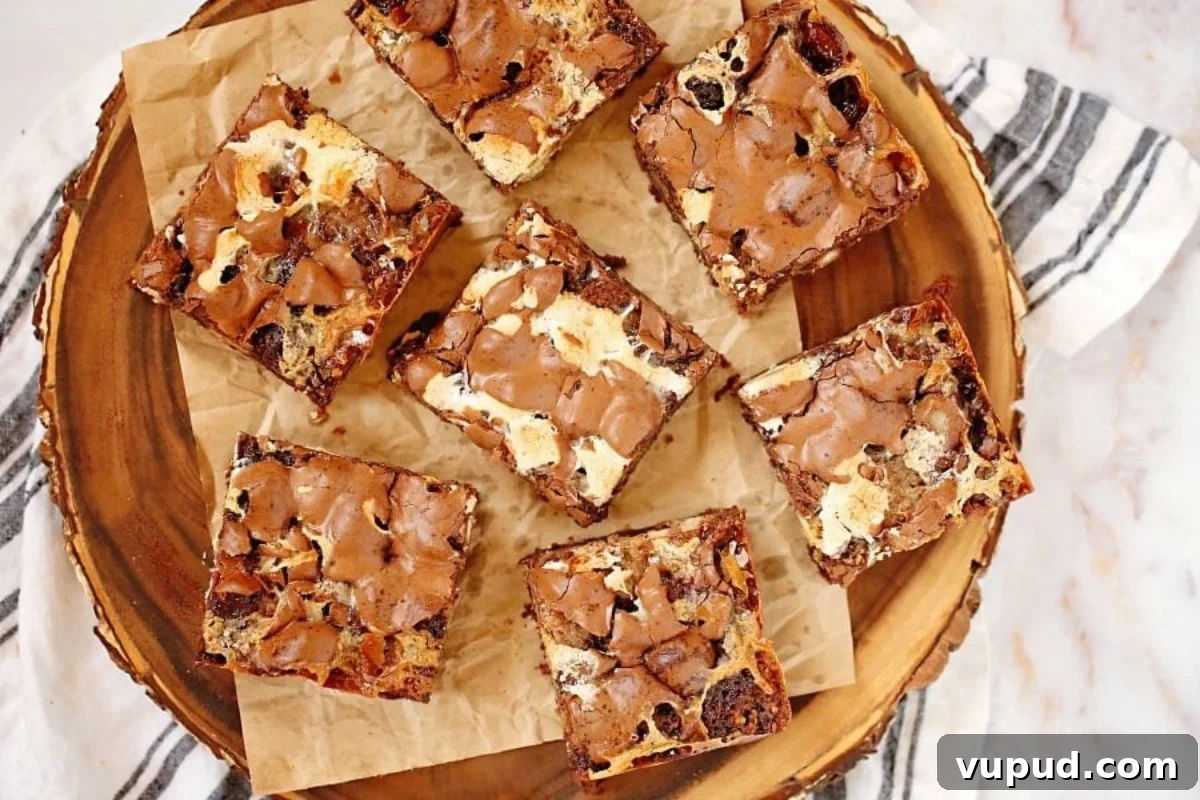 24 Irresistible S'mores Recipes to Enjoy All Year Long 9 A plate of homemade marshmallow-topped brownies on a wooden surface.
