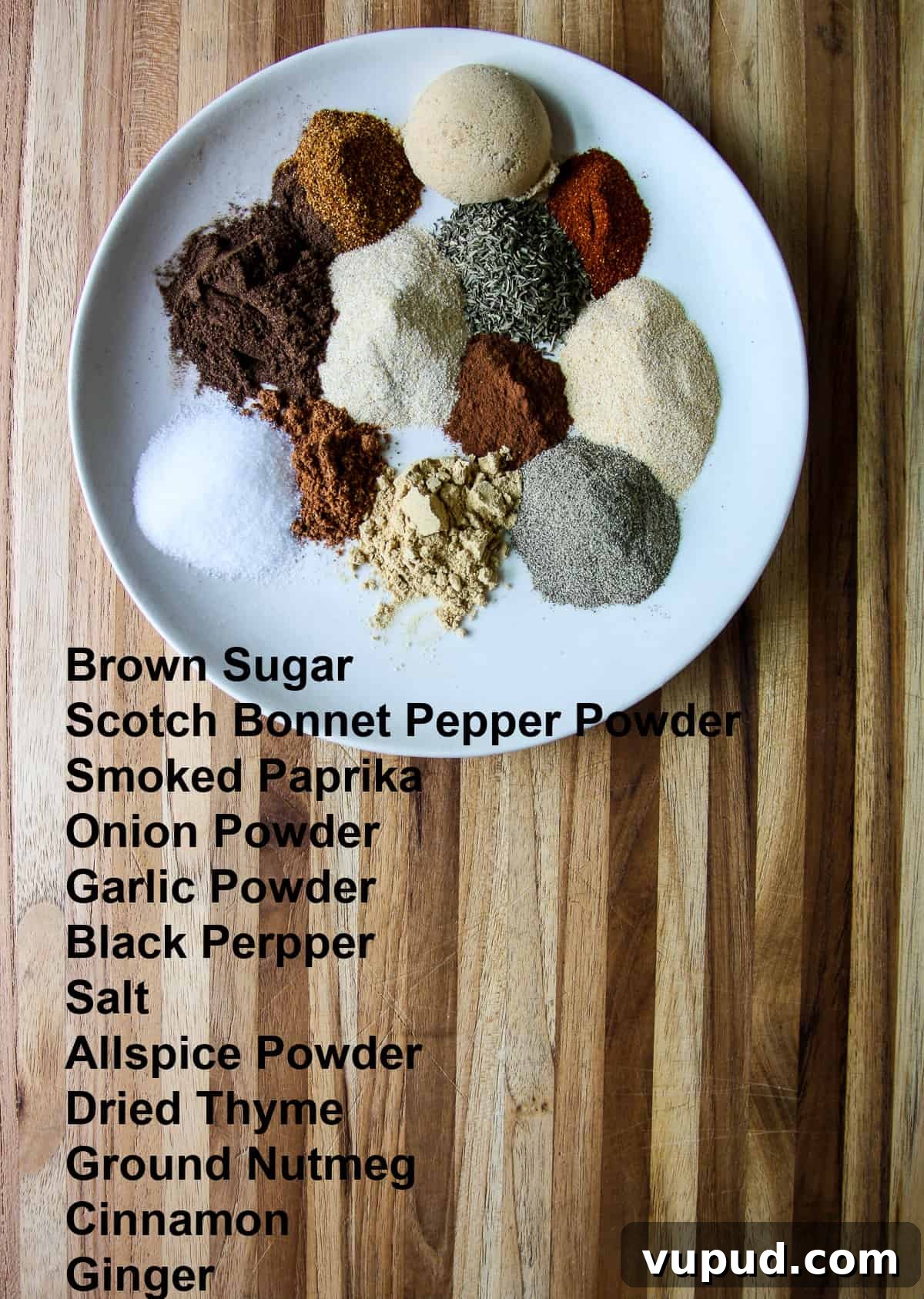 All of the individual ingredients for making Jamaican jerk seasoning blend on a white plate.