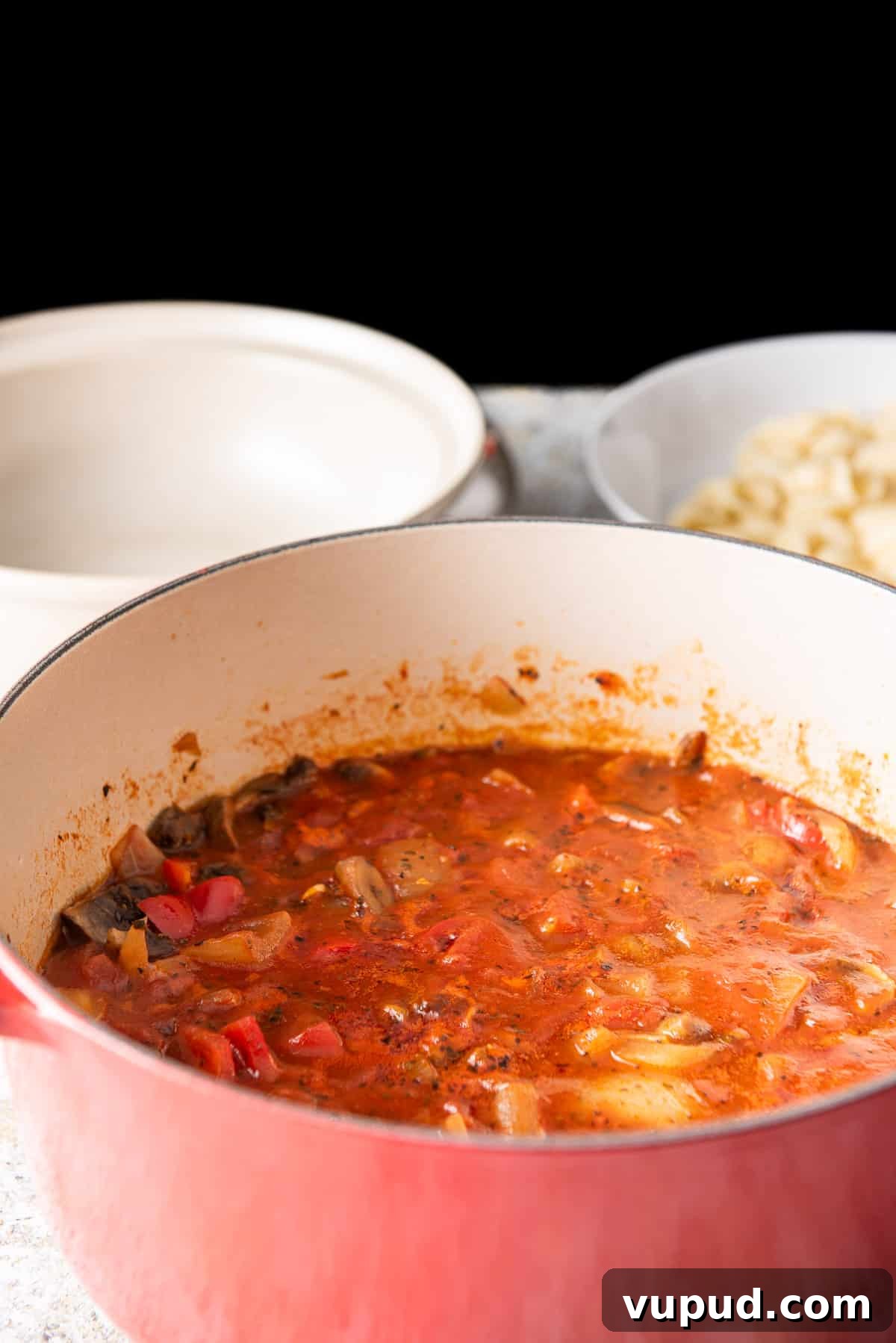 Rich Tomato Gravy Recipe: Savory Red Sauce for Pasta & Biscuits 8 The gravy fully cooked but still in the pan. There is a beige bowl in the background and pasta in a dish