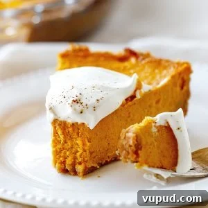 Pumpkin Pie with Graham Cracker Crust Recipe for Fall Baking 15 White plate with bitten slice of pumpkin pie, fork with bite beside it
