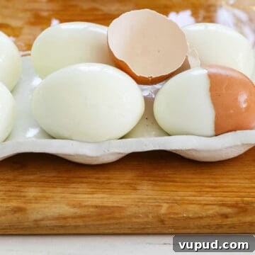 Festive Christmas Deviled Eggs Recipe for Holiday Parties 3 6 perfectly hard boiled eggs with a cracked half of an egg shelf on top.