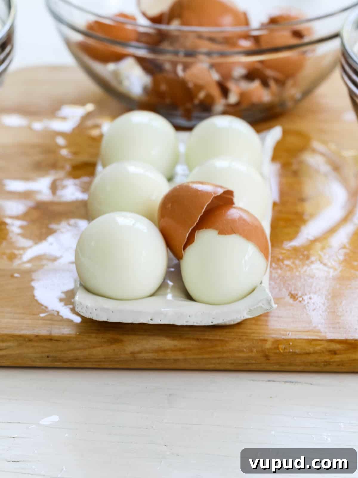 Festive Christmas Deviled Eggs Recipe for Holiday Parties 4 A white ceramic egg holder filled with freshly steamed hard boiled eggs.