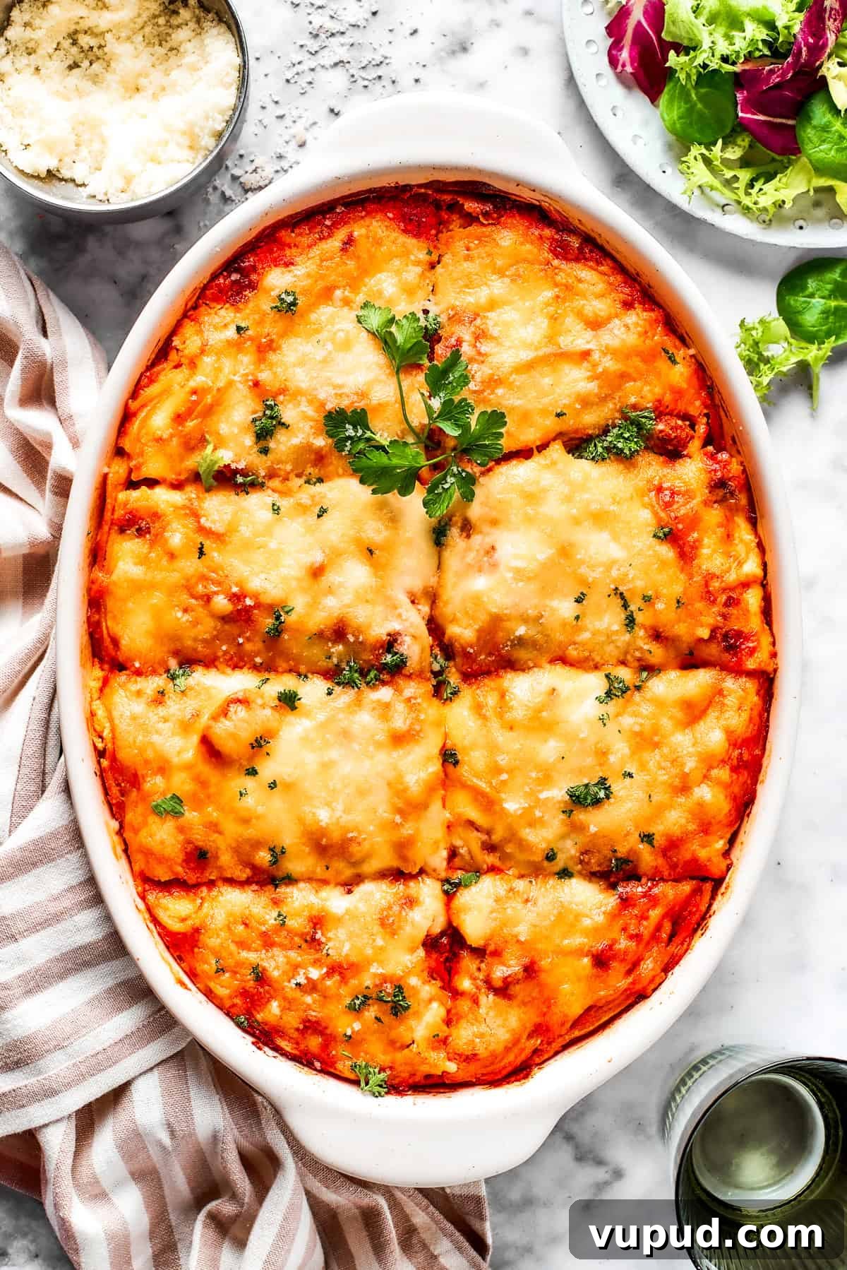 Million dollar spaghetti is an easy spaghetti casserole made from pasta tossed in homemade meat sauce and baked with layers of melty cheese. Overhead image of baked million dollar spaghetti in a casserole dish.