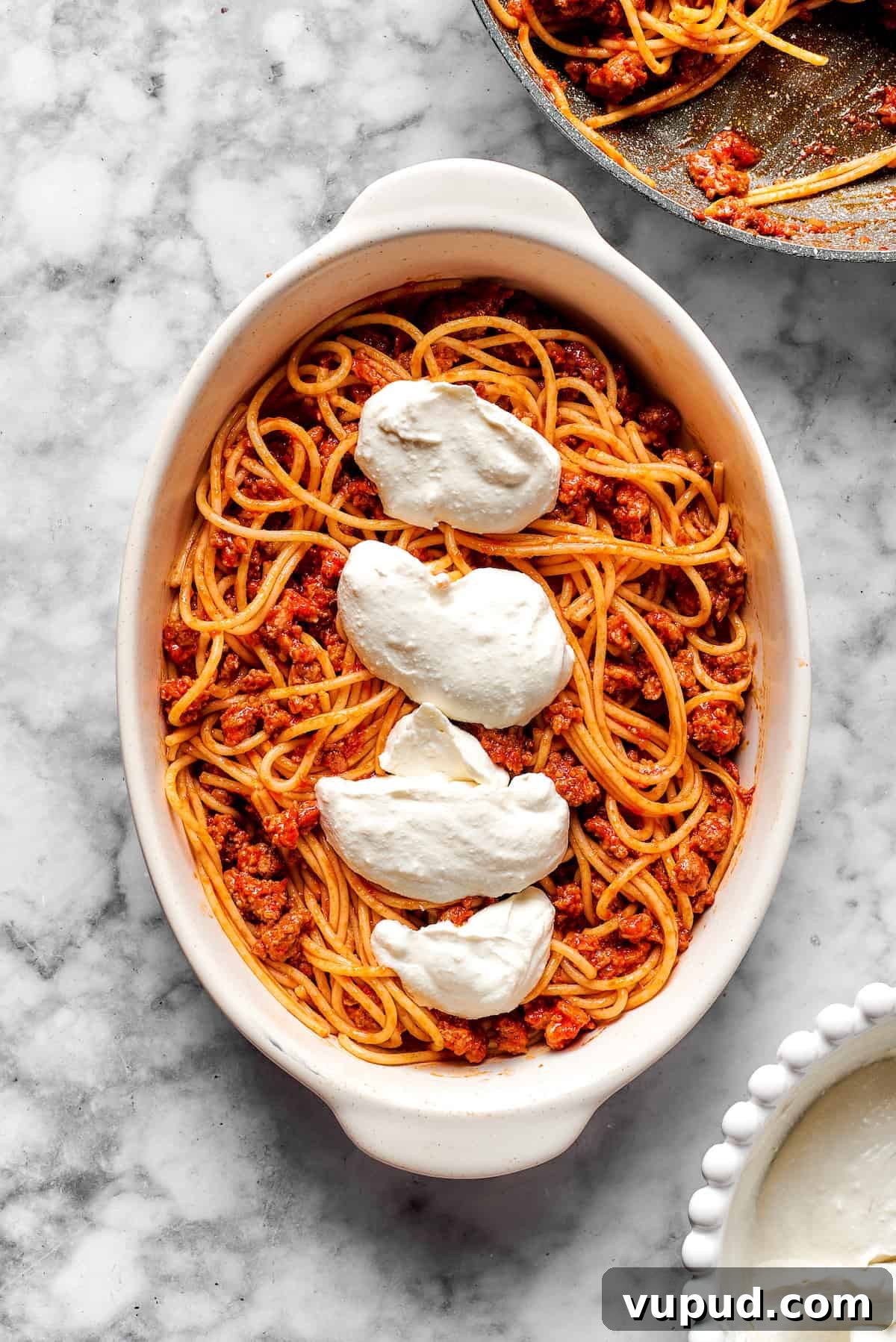 Mix the cooked pasta & meat sauce, and add the cheese mixture. Adding cheese mixture on top of spaghetti.