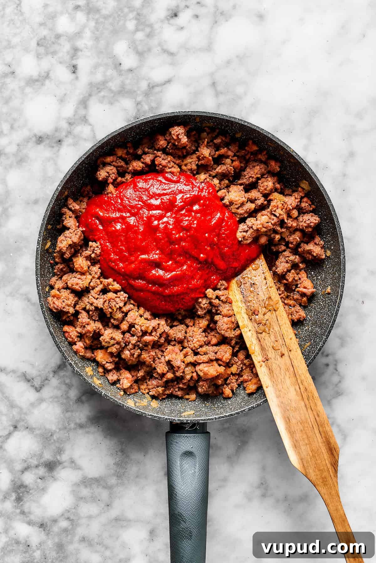 Million-Dollar Spaghetti Recipe: Decadent Creamy Garlic Pasta 3 Adding pasta sauce to a skillet with cooked meat.