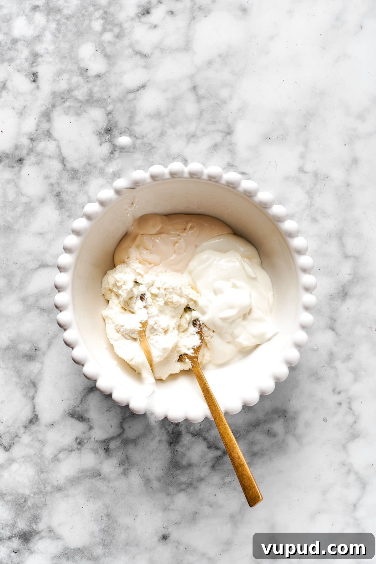 Mix cheeses together. Added cheese mixture ingredients to a white bowl.