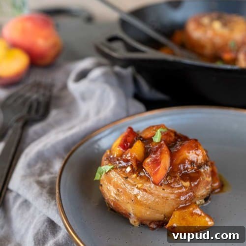 Whiskey-Peach Glazed Bacon-Wrapped Pork Loin Filets 11 overhead shot of bacon-wrapped pork loin filet on plate by pan of filets.