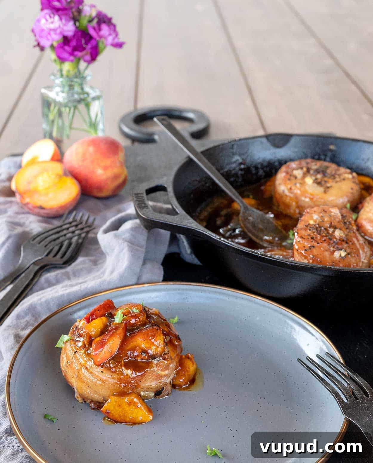 Whiskey-Peach Glazed Bacon-Wrapped Pork Loin Filets 9 overhead shot of bacon-wrapped pork loin filet on plate by pan of filets.