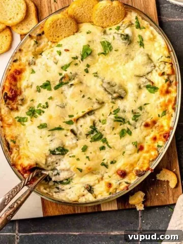 Crab spinach artichoke dip on a cutting board.