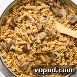 How to make creamy vegan mushroom stroganoff: Mushrooms and pasta tossed with cashew cream sauce after simmering.