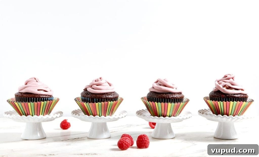 Chocolate Raspberry Cupcakes with Fresh Raspberry Buttercream 3 A line of cupcakes in striped wrappers on top of white stands