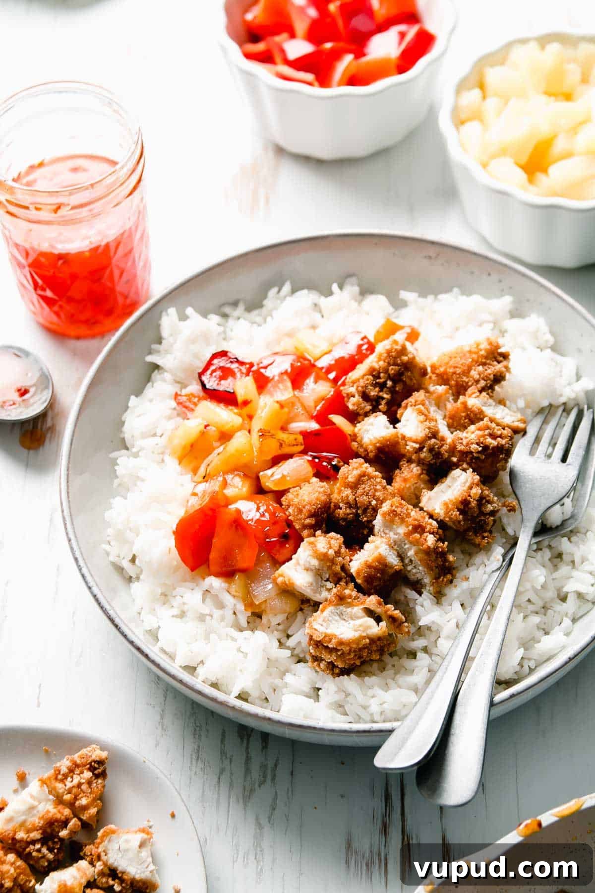 Gluten-Free Sweet Fire Chicken Recipe — Panda Express Copycat 5 Gluten-free sweet fire chicken in a bowl over steamed rice with two forks.