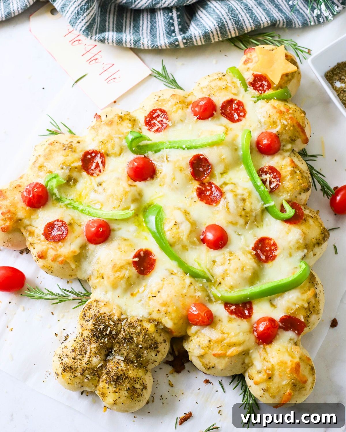 27+ Festive Christmas Finger Food Appetizers for Holiday Parties 3 A Christmas tree pizza with peppers and tomatoes as ornaments.