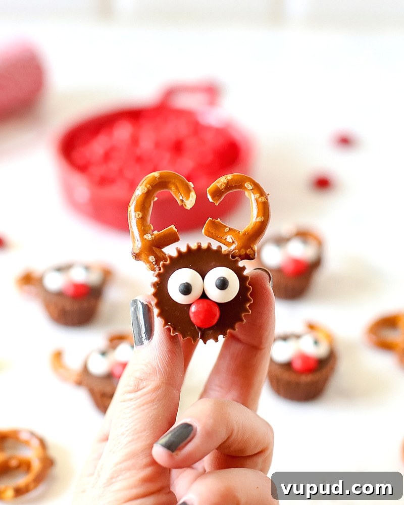 27+ Festive Christmas Finger Food Appetizers for Holiday Parties 22 Fingers holding a Reese's Reindeer