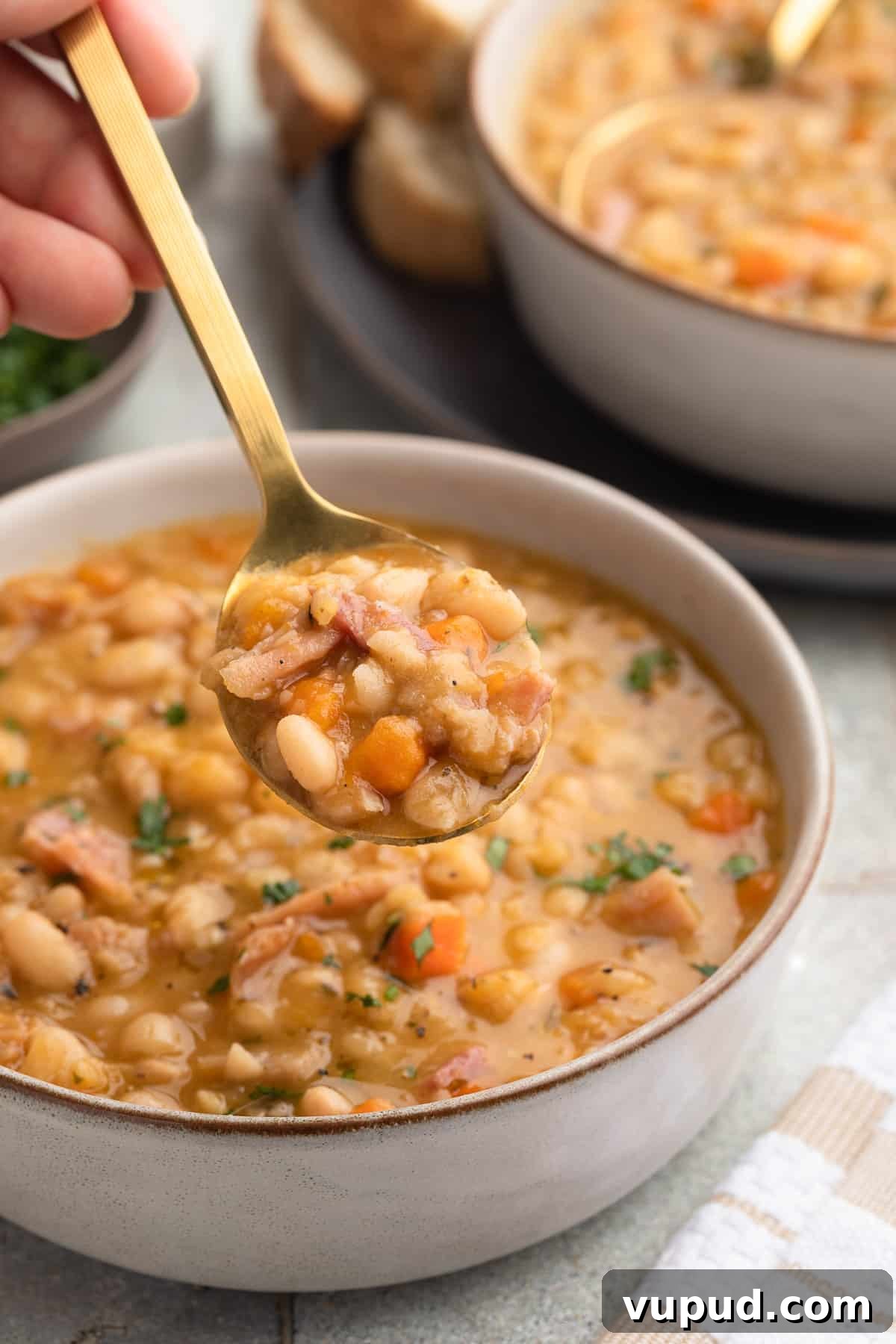 Classic Ham and Bean Soup Recipe for Comforting Weeknight Meals 14 spoonful of ham and bean soup held over a bowl of the soup