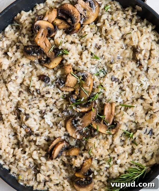 Creamy Mushroom Risotto with Rosemary and Parmesan 6 risotto topped with mushrooms in a pan