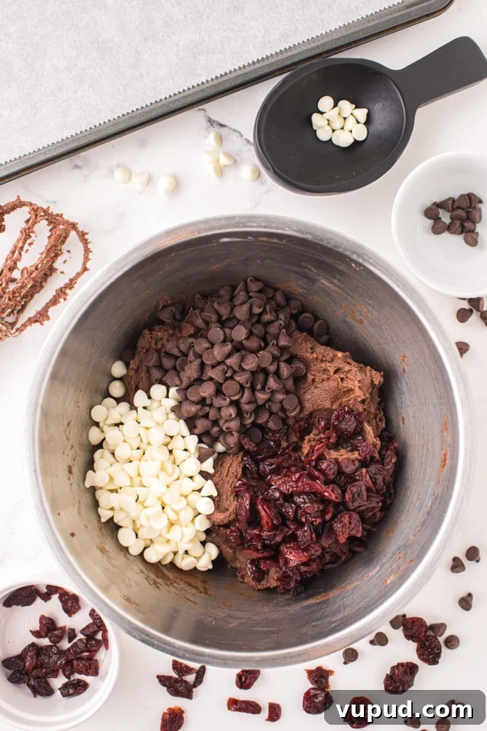 black forest cookie dough batter with chocolate chips, white chocolate chips and dried cherries in bowl