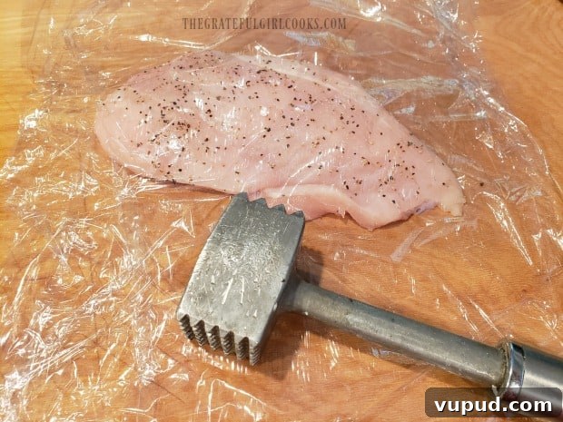 Pounding chicken Chicken being pounded between plastic wrap
